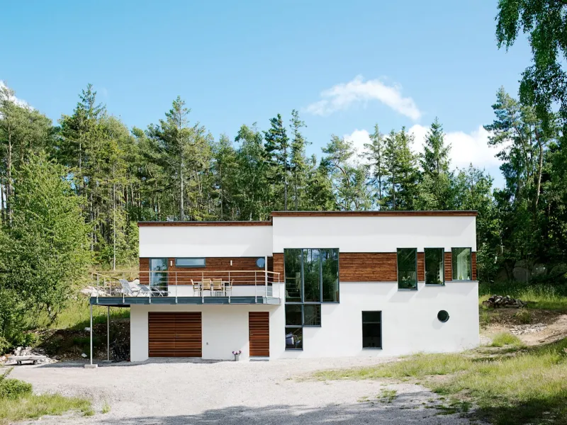 Vitt hus med trädetaljer i brunt lasyr